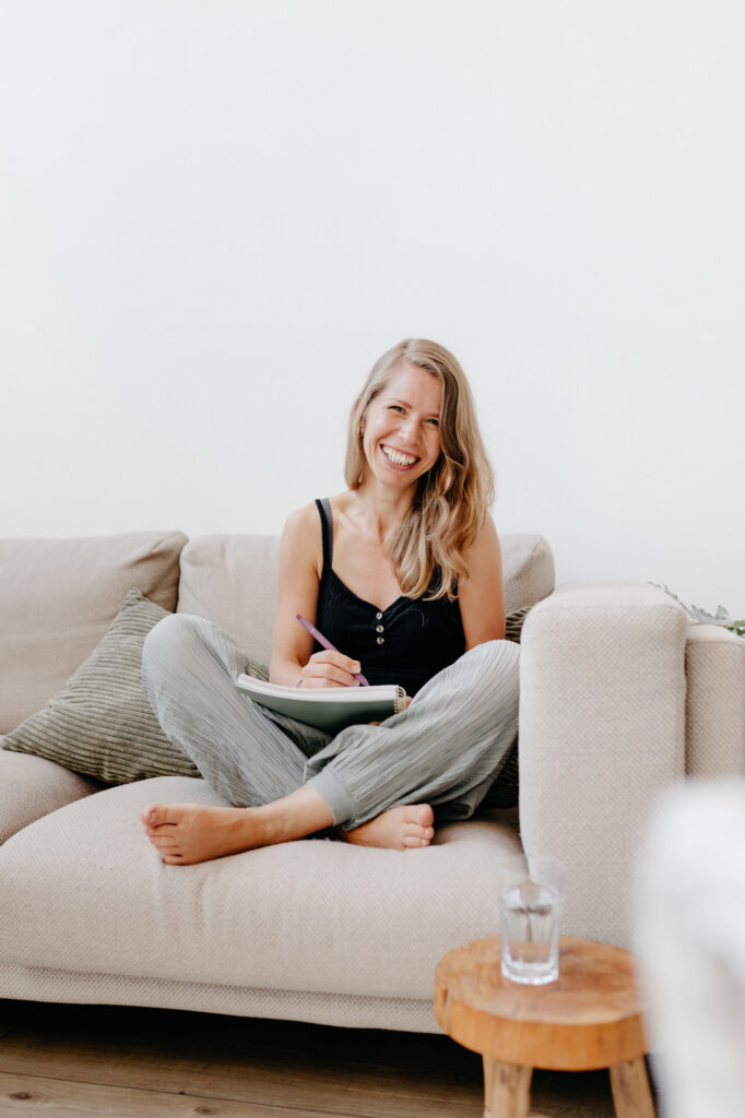Kathrin mit Notizblock auf dem Sofa