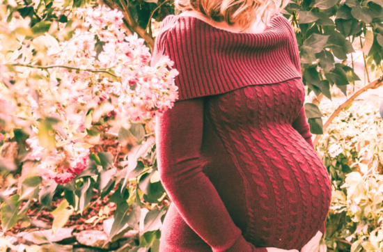 Mother’s Blessing – schwangere Frau inmitten von Blüten und Grün